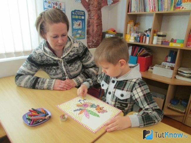 Мальчик создает рисунок по технике энкаустика