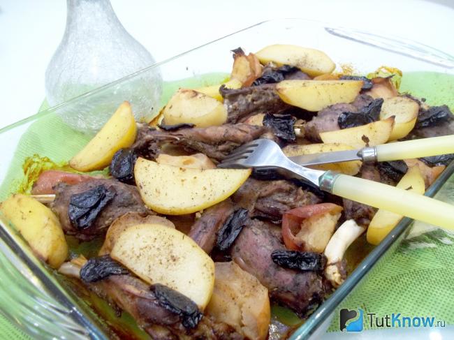 Готовая утка кусочками с картофелем, яблоками и черносливом