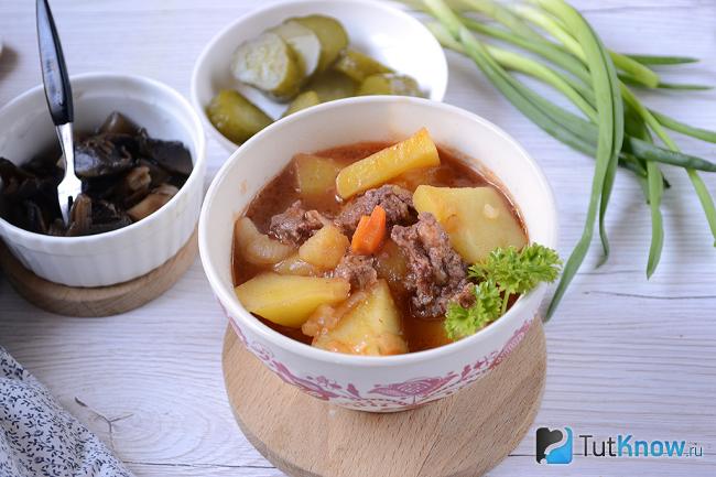 Готовая картошка с тушёнкой в тарелке