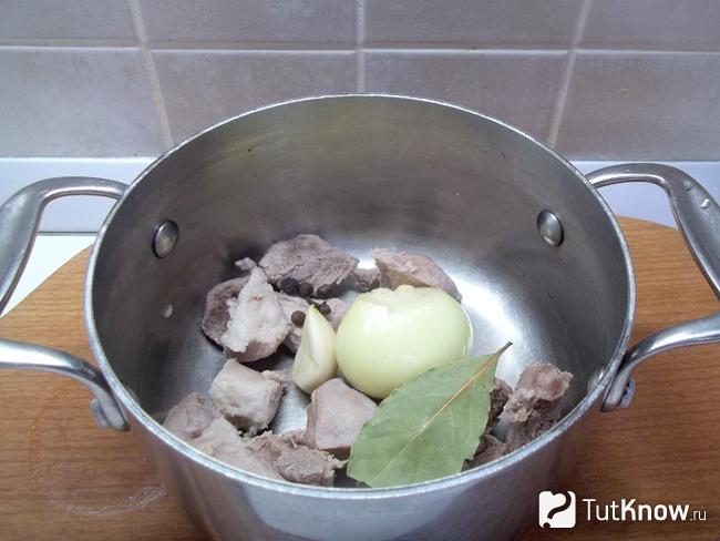 Мясо опущено в кастрюлю с луком и другими пряностями