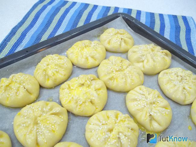 Пирожки смазаны яйцом и присыпаны кунжутом