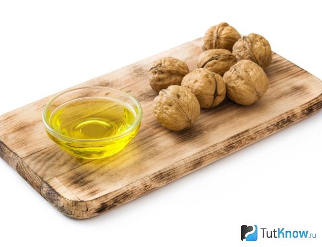 Грецкие орехи и масло на разделочной доске