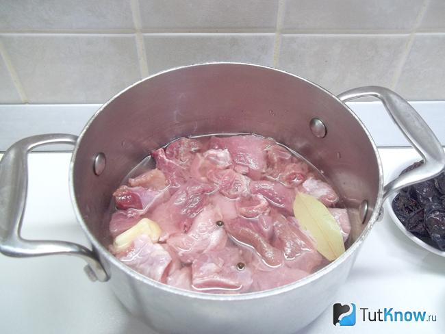 Мясо сложено в кастрюлю и залито водой