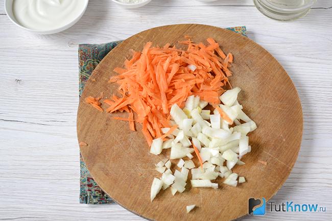 Измельченная морковь и лук на кухонной досточке