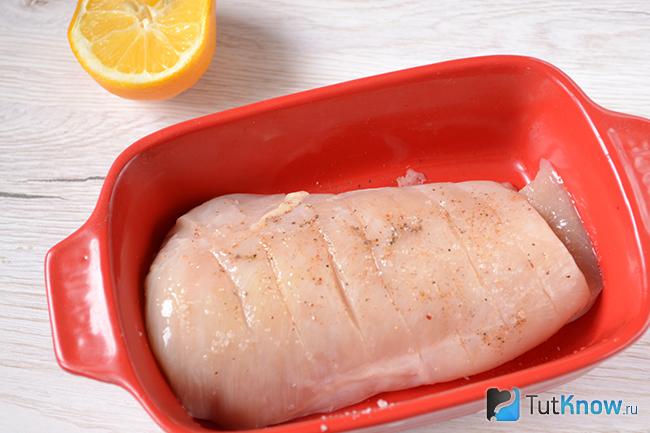 Кусок куриного филе, обмазанного солью и молотым перцем