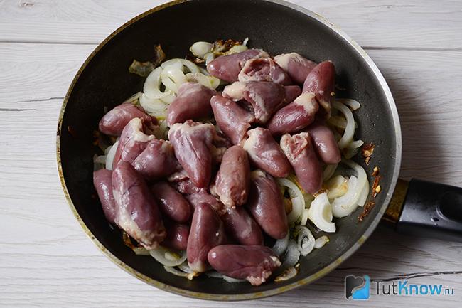 Куриные сердечки выложены поверх лука и чеснока