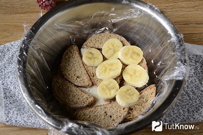 Бананы и пряники в глубокой миске, покрытой пищевой плёнкой