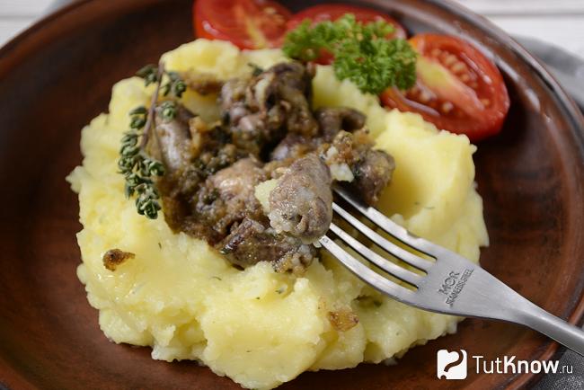 Куриные сердечки, жаренные на сковороде с луком, крупным планом