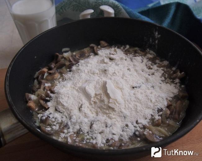 Добавление муки к грибной смеси на сковороде