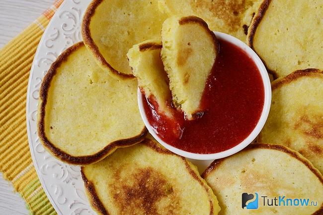 Разломанный оладушек в пиале с джемом