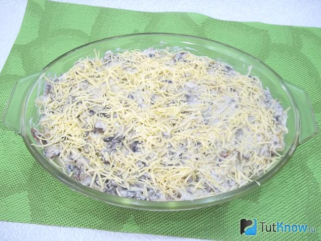 Запеканки из пельменей с грибами присыпана сыром
