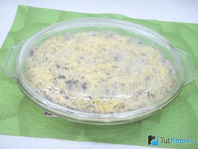 Запеканки из пельменей с грибами и сыром прикрыта крышкой
