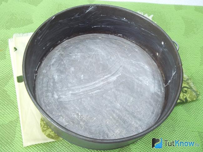 Форма для выпечки шоколадной королевской ватрушки застелена пергаментом и смазала сливочным маслом