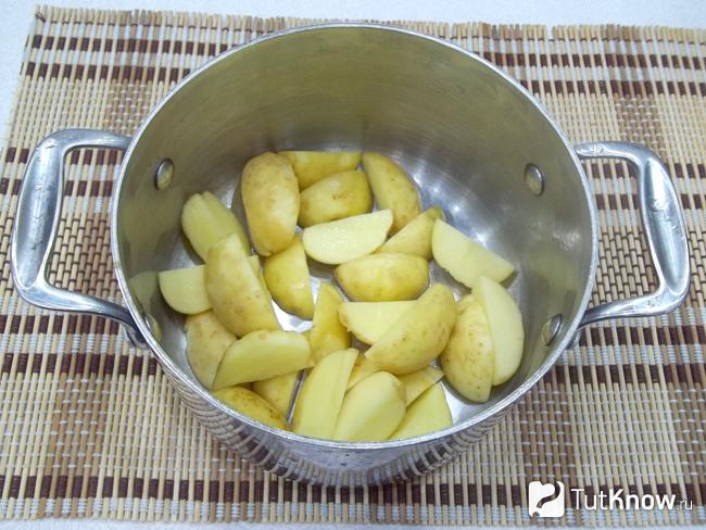 Очищенный картофель нарезан дольками и сложен в кастрюлю