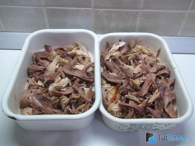 Мясо петуха отделено от кости, нарезано кусочками и разложено по лоткам