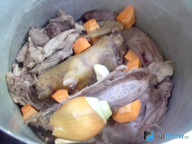 В чистую кастрюлю опущен петух, копыто, морковь, чеснок и репчатый лук