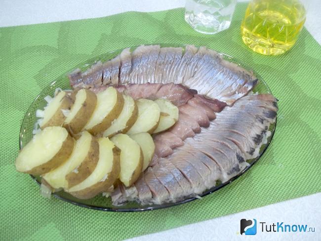 Картофель выложен на блюдо к селедке с луком