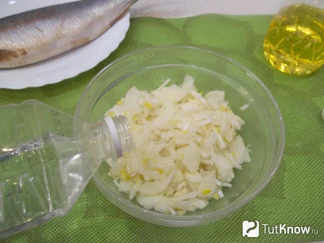 Репчатый лук сложен в миску, заправлен сахаром и столовым уксусом