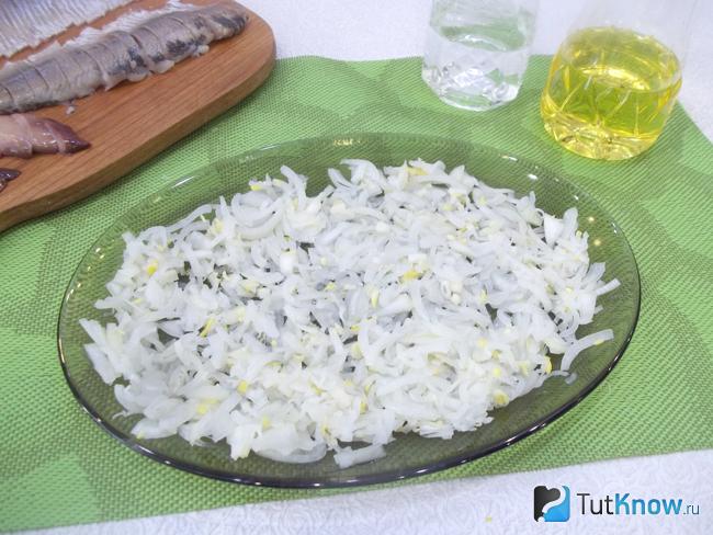 Маринованный репчатый лук выложен в сервировочное блюдо