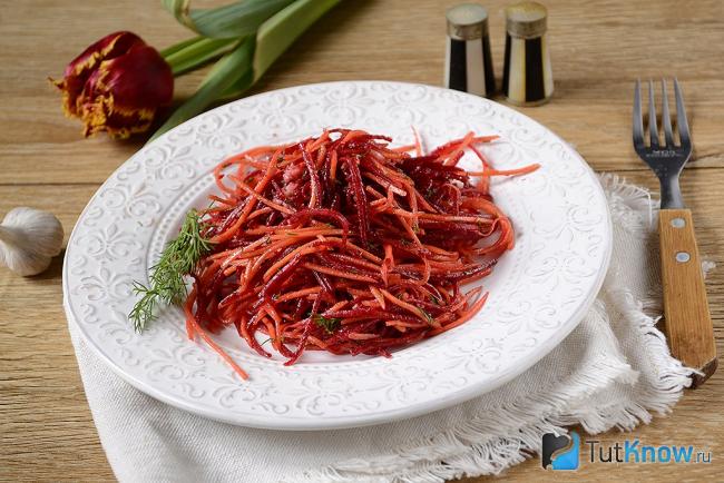 Тарелка с салатом из сырой свеклы и морковки