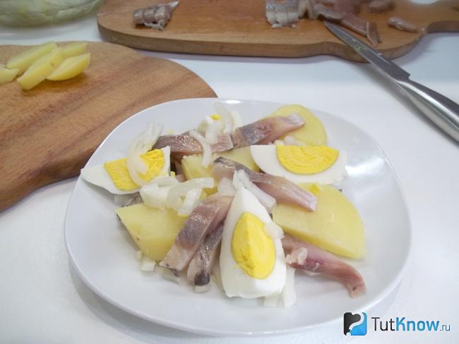 Салат с селедкой, картофелем, яйцами и луком заправлен растительным маслом