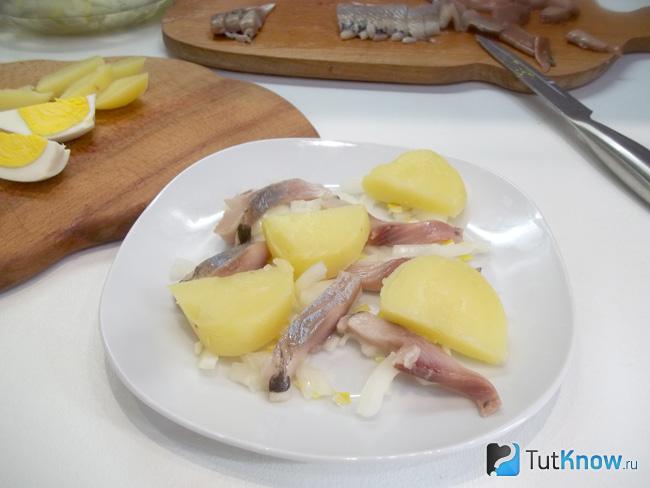На селедку выложены кусочки картофеля