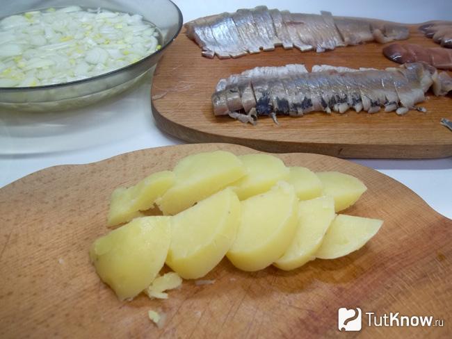 Отварной картофель очищен от кожуры и нарезан дольками