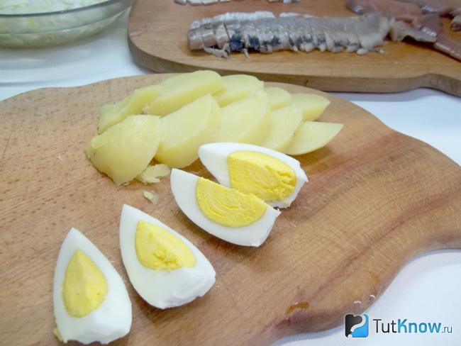 Отварные яйца очищены от скорлупы и нарезаны дольками