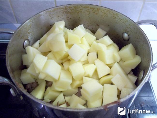В кастрюлю с мясом с луком добавлен картофель нарезанный кусочками