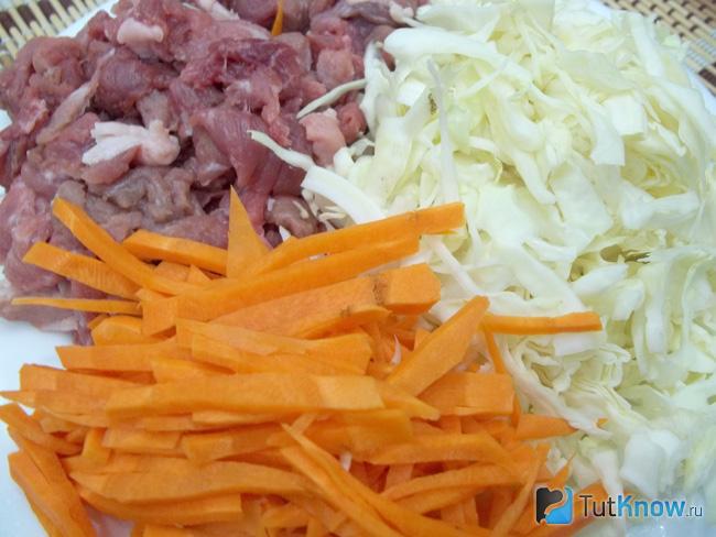 Капуста тонко нашинкована, морковь очищена и нарезана тонкой соломкой, мясо вымыто и нарезано средними кусочками