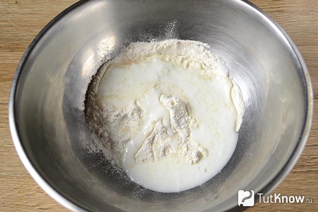 Тёплый кефир добавлен в миску с мукой и дрожжами