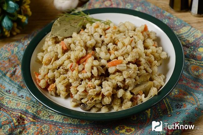 Постная перловая каша с грибами и овощами подана к столу