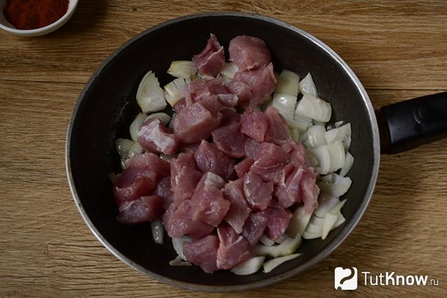 Куски мяса добавлены к луку