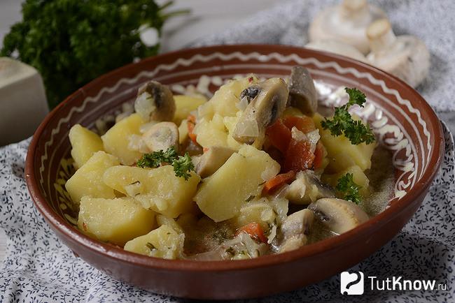 Готовая тушеная картошка с грибами и сметаной крупным планом