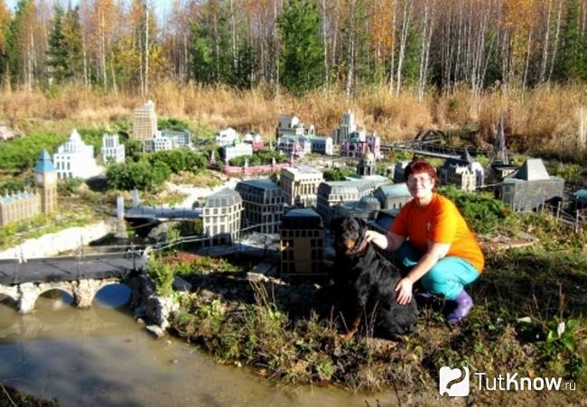 Женщина сидит напротив большого макета города