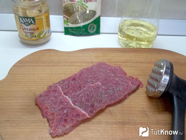 Мясо нарезано кусочками и отбито кухонным молоточком