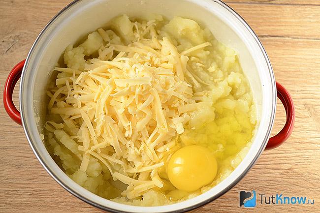 Тёртый сыр и яйцо добавлены в кастрюлю с варёным картофелем
