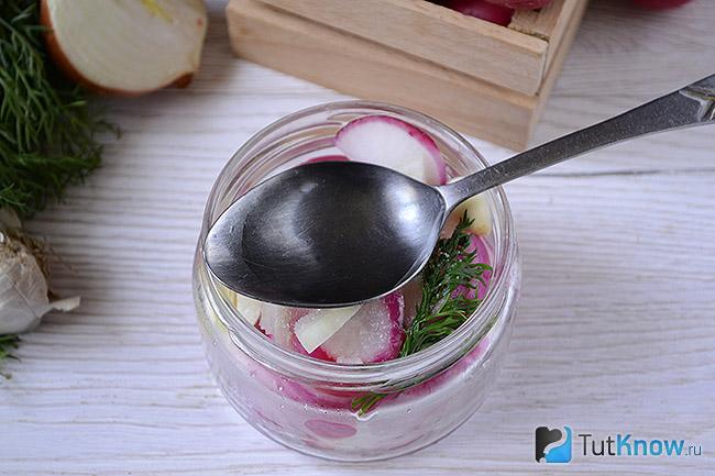 Ложка уксуса над банкой с дольками редиса