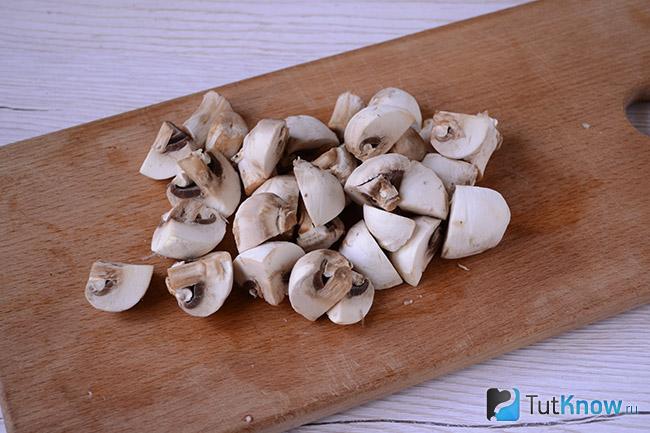 Нарезанные грибы на кухонной доске