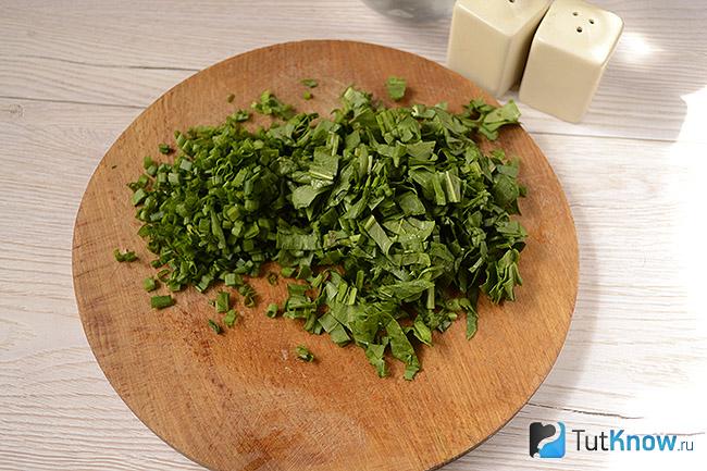 Рубленная зелень на кухонной дощечке