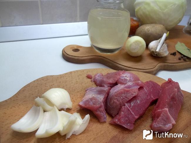 Мясо и лук нарезаны для мясорубки