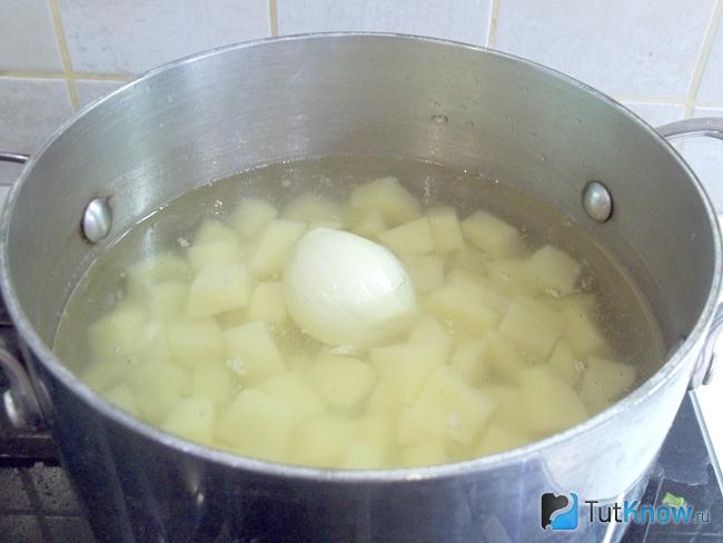 Картофель с очищенной луковицей залит бульоном