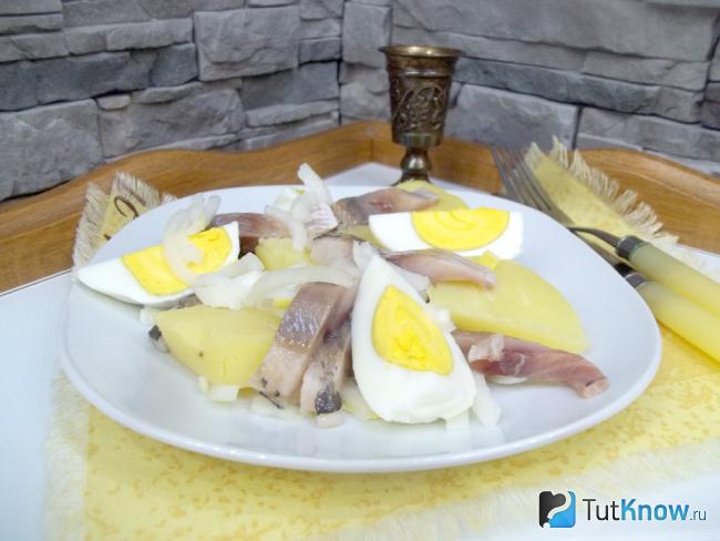 Готовый салат с селедкой, картофелем, яйцами и луком