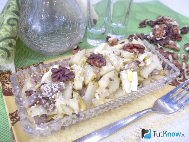 Готовый салат с грушей, мясом и орехами в лимонном соке