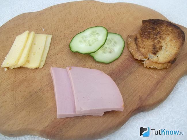Колбаса, сыр и огурцы нарезаны тонкими слайсами