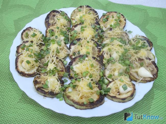 Готовые жареные кабачки с чесноком, майонезом, сыром и луком