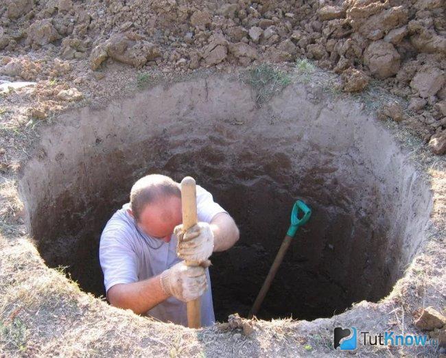 Рытье котлована для выгребной ямы из бетонных колец