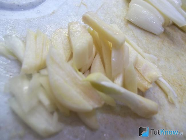 Лук и чеснок очищены и нарезаны соломкой