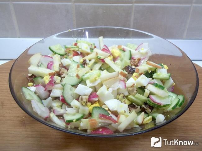 Готовый салат из огурцов, редиски, яблок, яиц и орехов