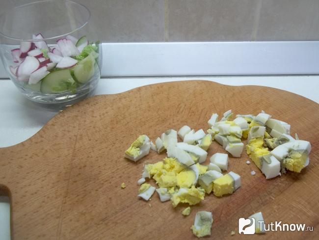 Отваренные яйца нарезаны кубиками